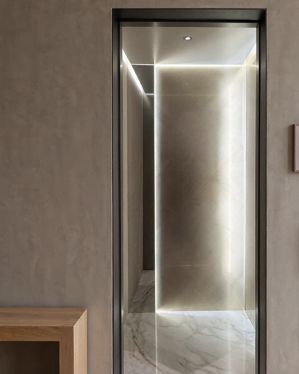 A finished SINNVO cabin set into a violet showroom wall, doors open and interior lit